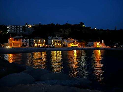 a city at night with lights on the water at Marvel Sea View 3 in Akrogiali