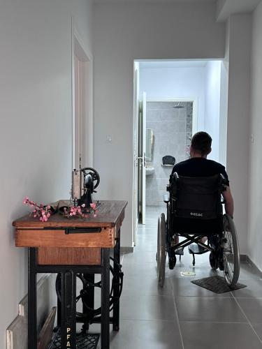 a man in a wheelchair sitting at a table in a room at Marvel Sea View 3 in Akrogiali