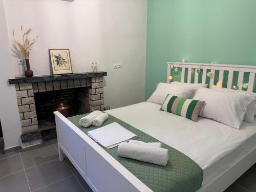 a bed with towels on it in a room with a fireplace at Marvel Sea View 3 in Akrogiali