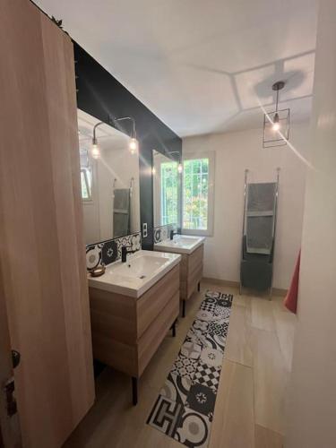 une grande salle de bains avec deux lavabos et deux miroirs dans l'établissement Villa authentique avec piscine, jardin, à Montélimar