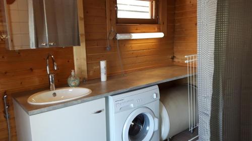 a bathroom with a washing machine and a sink at Huvila Lahdenranta in Räyrinki