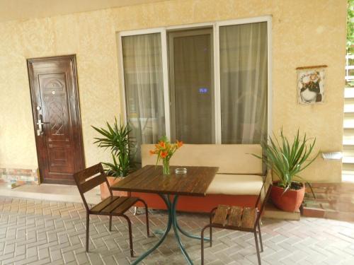 a patio with a table and chairs and a window at ApartHotel Dom in Odesa