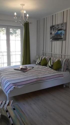 a bedroom with a large bed with a striped blanket at Rooms Villa Harmonie - Adults Only +14 in Crikvenica