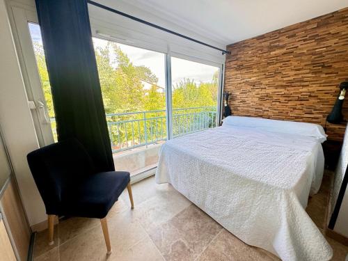 une chambre avec un lit et une grande fenêtre dans l'établissement Appartement Le clos des anges, à Cogolin