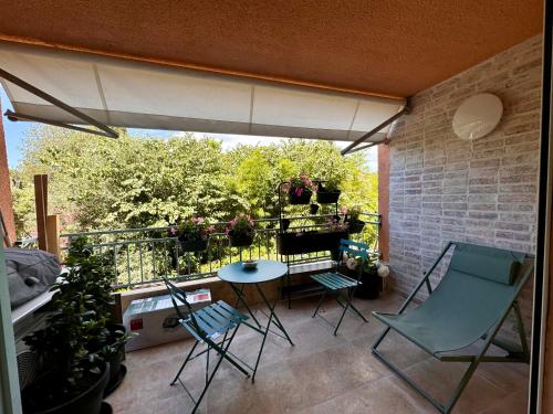 un patio avec des chaises et une table sur un balcon dans l'établissement Appartement Le clos des anges, à Cogolin