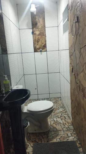 une salle de bains avec toilettes et lavabo dans l'établissement Kitnet Girassol, à São Thomé das Letras