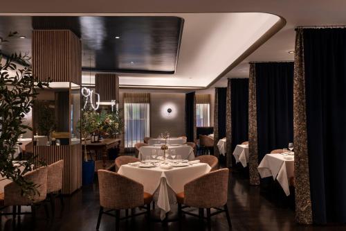 ein Esszimmer mit Tischen und Stühlen und einem großen Bildschirm in der Unterkunft The Knickerbocker in New York