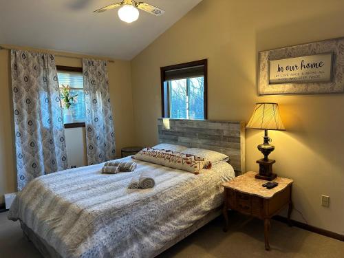 a bedroom with a bed and a table with a lamp at WOW!! Ultimate Pocono Retreat, Hot Tub, Game Room, Deck, Lakes, Skiing, Pools in Long Pond