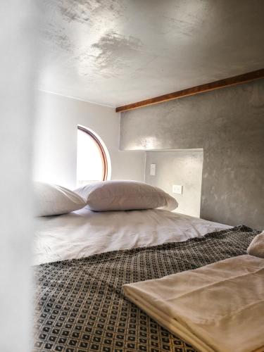 a bedroom with a bed and a window at Caracola Boutique Hostel in El Paredón Buena Vista