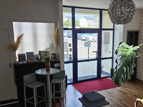 a living room with a table and a large window at hotel terminus auray in Auray