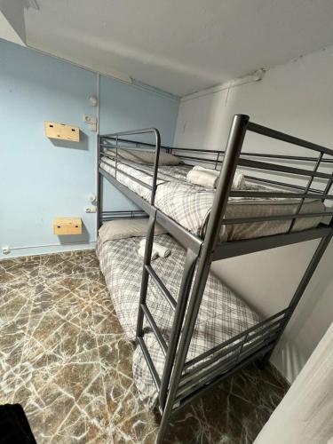 two bunk beds in a room with marble floors at Vacansis Habitaciones Privada en una Villa a un paso del Mar en Cullera in Cullera