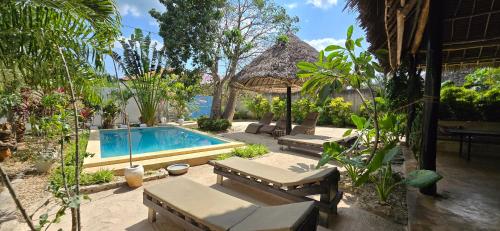 a resort with a swimming pool and some plants at Salama & Mbuyuni Bungalows in Matemwe