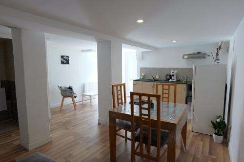 une cuisine et une salle à manger avec une table et un réfrigérateur dans l'établissement L'entre deux, à Entrelacs
