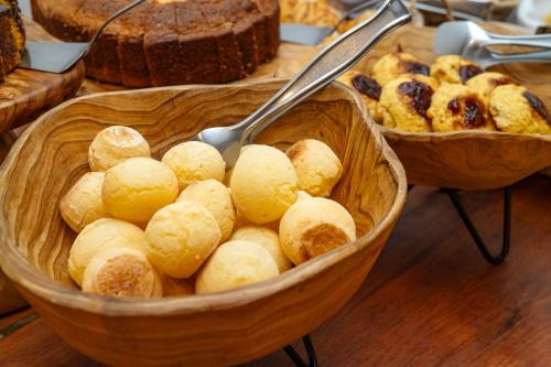 two baskets of bread and pastries on a table at Pousada Porto Fino in Cabo Frio