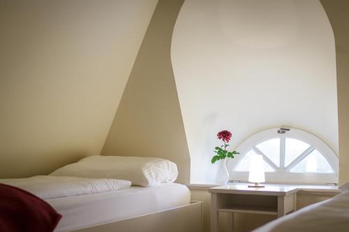 two beds in a room with a window at Hotel Aarnhoog in Keitum