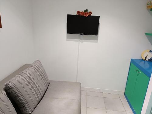 a living room with a couch and a tv on a wall at Casa Vacanze Margarita in SantʼAlessio Siculo