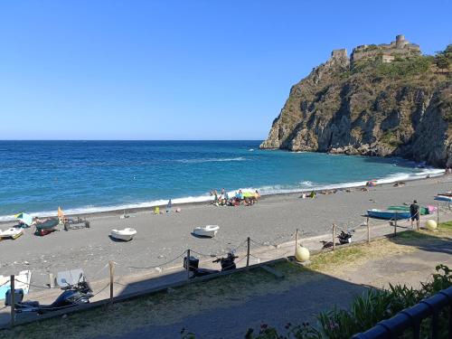 a beach with people on the sand and the ocean at Casa Vacanze Margarita in SantʼAlessio Siculo
