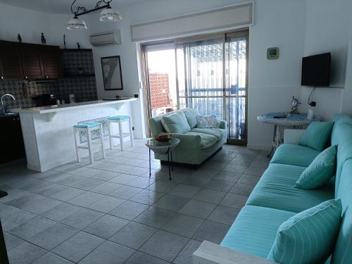 a living room with a couch and a kitchen at Casa Vacanze Margarita in SantʼAlessio Siculo