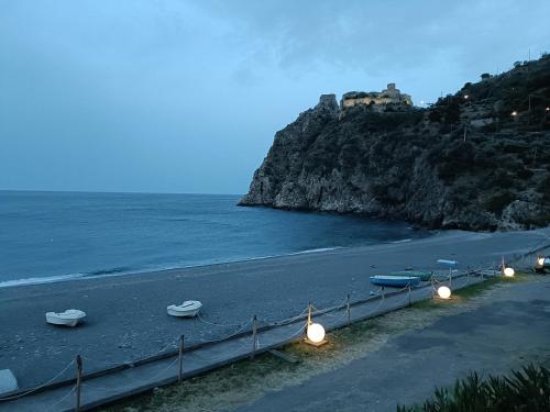a beach with lights and boats on the water at Casa Vacanze Margarita in SantʼAlessio Siculo