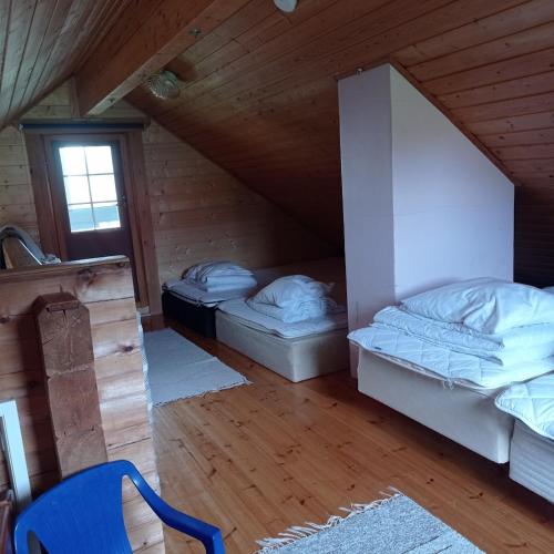 a attic room with two beds and a window at Huvila Lahdenranta in Räyrinki