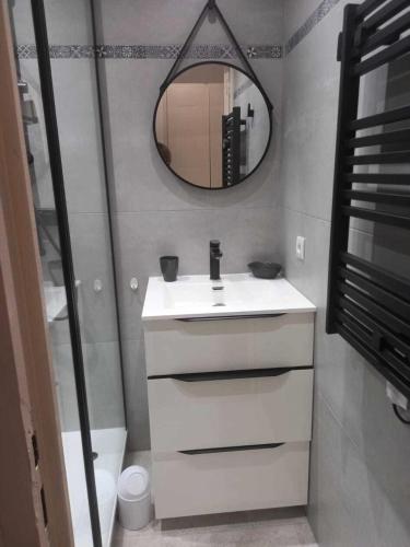 une salle de bain avec un lavabo blanc et un miroir dans l'établissement Résidence le Village de Cap Esterel - maeva Home - Appartement 2 Pièces 4 Personnes - Sélection MAE-3114, à Saint-Raphaël