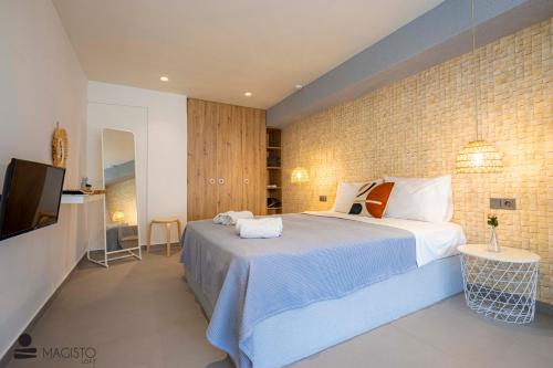 a bedroom with a large bed and a television at Magisto Loft in Nea Moudania