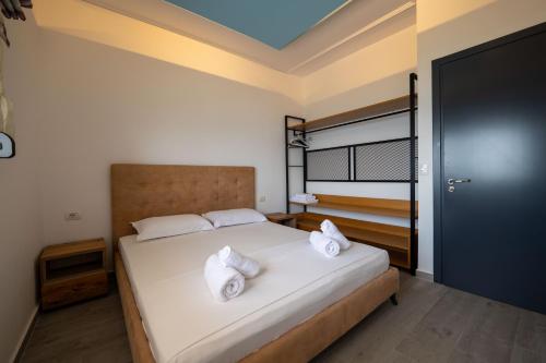 a bedroom with a large bed with white pillows at Franklin Rooms in Sarandë