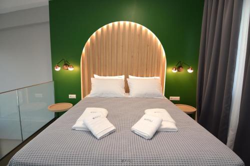 a bedroom with a large bed with two white towels at Mavili Luxury Apartments in Kavala