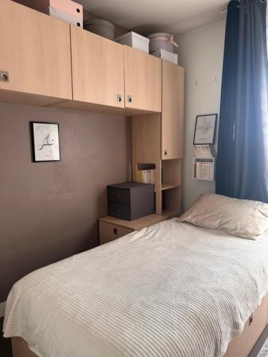 - une chambre avec un lit, des armoires et une télévision dans l'établissement Studio vue sur la Tour Eiffel, à Nogent-sur-Marne