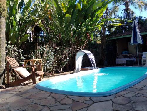 a swimming pool with a water fountain at Refúgio do Kairós in Ubatuba