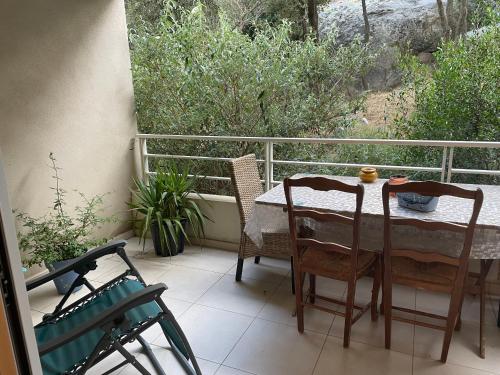 une table et des chaises assises sur un balcon avec vue dans l'établissement Joli Appartement proche centre ville, à LʼÎle-Rousse