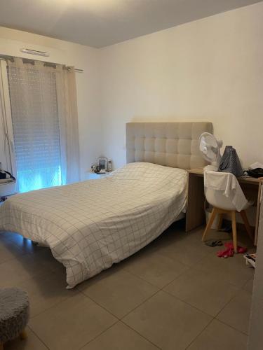 une chambre avec un lit, un bureau et une chaise dans l'établissement Joli Appartement proche centre ville, à LʼÎle-Rousse