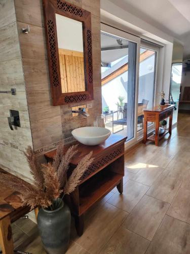 a bathroom with a sink and a large mirror at Wellness Apartmány EMPORIO in Loštice