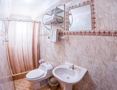 a bathroom with a sink and a toilet and a mirror at Eco Home View - Guest House in Cusco