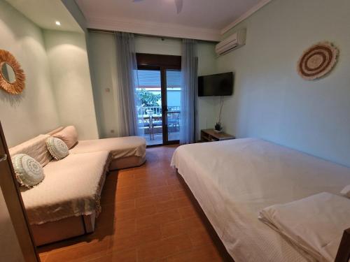 a hotel room with two beds and a television at Pnoe Studios in Nea Moudania