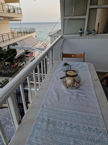 a table on a balcony with a view of the ocean at Pnoe Studios in Nea Moudania