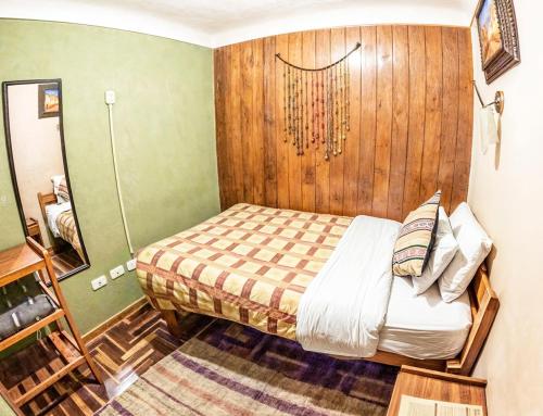 a bedroom with a bed and a wooden wall at Eco Home View - Guest House in Cusco