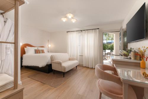 a bedroom with a bed and a desk with a chair at Petit Soleil - Bed, Breakfast and Bar in San Luis Obispo