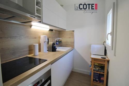 une cuisine avec un comptoir avec un évier et un micro-ondes dans l'établissement Villa Mozart - 6 couchages, à Sausset-les-Pins