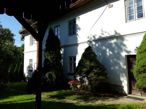 a white house with trees in the yard at Chalupa Sehradický mlýn in Sehradice