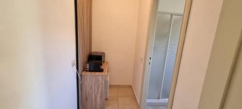 a hallway with a room with a microwave on a table at Villa Red Melons Portoscuso in Portoscuso