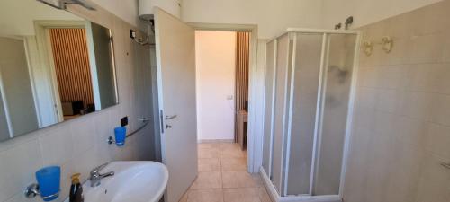 a bathroom with a white sink and a shower at Villa Red Melons Portoscuso in Portoscuso