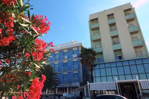 a building with red flowers in front of a building at San Marco in Marotta