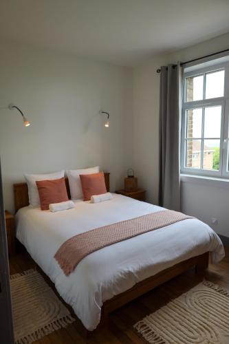 un grand lit dans une chambre avec une grande fenêtre dans l'établissement Appartement Le Télégraphe, à Cassel