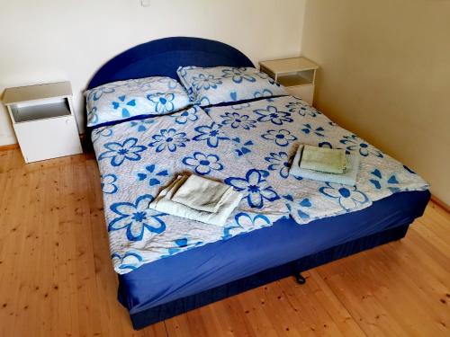 a bed in a bedroom with a blue comforter at Németh Apartmanház in Balatongyörök
