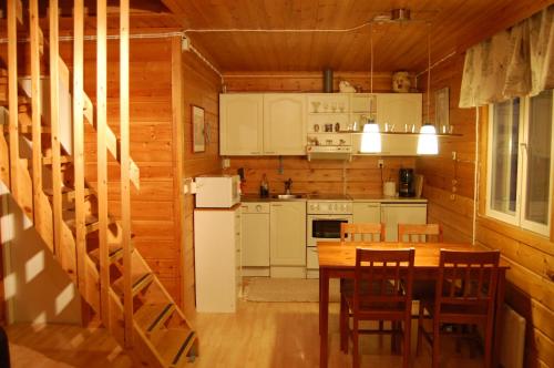 a kitchen and dining room with a table and chairs at Cottages RukaTupa in Ruka
