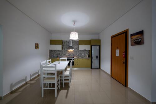 a kitchen and dining room with a table and chairs at Franklin Rooms in Sarandë
