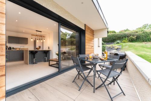 une extension en verre d'une maison avec une cuisine et une salle à manger dans l'établissement Joli T1 Bis avec Chambre - Cuisine - Salle de Bain, à Vallières