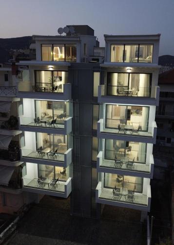 an apartment building with chairs on the balconies at Mavili Luxury Apartments in Kavala