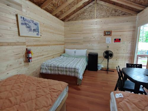 a room with two beds and a table in it at Oakhill Pines Campground in Bridgewater